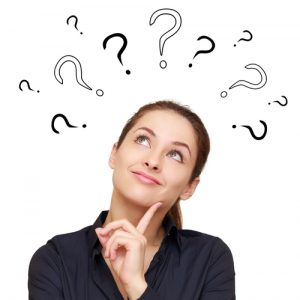 Woman looking up at question marks above her head