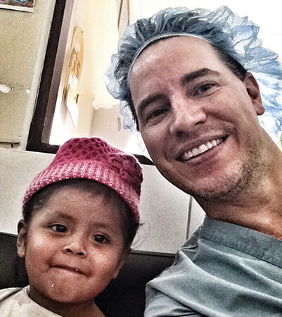 Dr. Stoeckel of Wake Plastic Surgery with a young patient in Bolivia