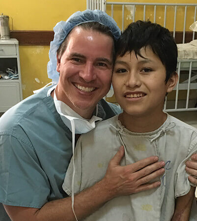 Dr. Stoeckel of Wake Plastic Surgery with a young patient in Bolivia